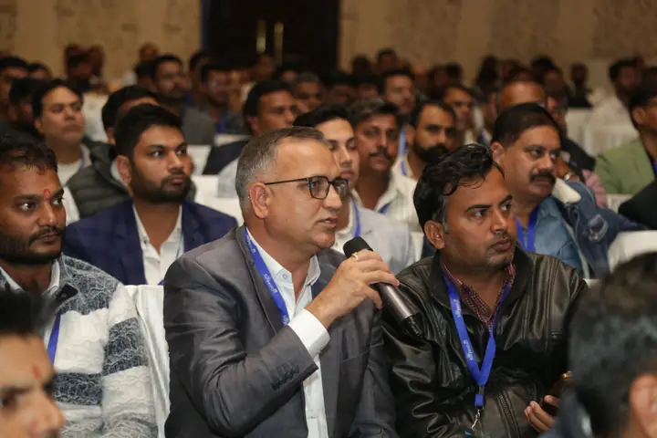 An attendee with a microphone asking a question during the 2025 gathering